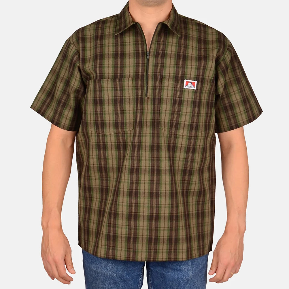 Model wearing a Ben Davis olive plaid short-sleeve half-zip shirt with chest logo front view